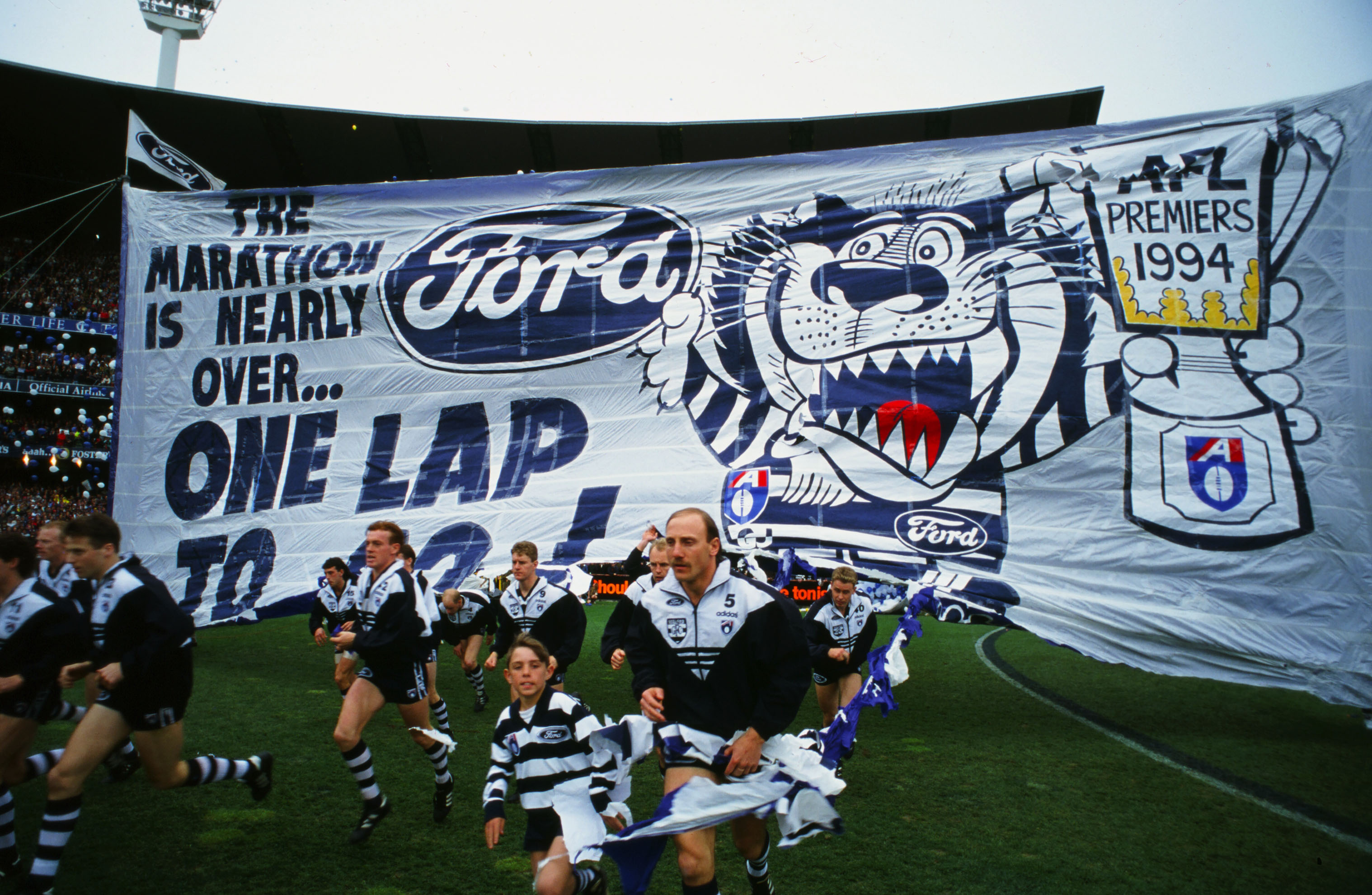 Gary Ablett and the Cats players run through the banner before the 1994 AFL Grand Final between the Geelong Cats and the West Coast Eagles at the Melbourne Cricket Ground. (image supplied courtesy of Bob Gartland)
