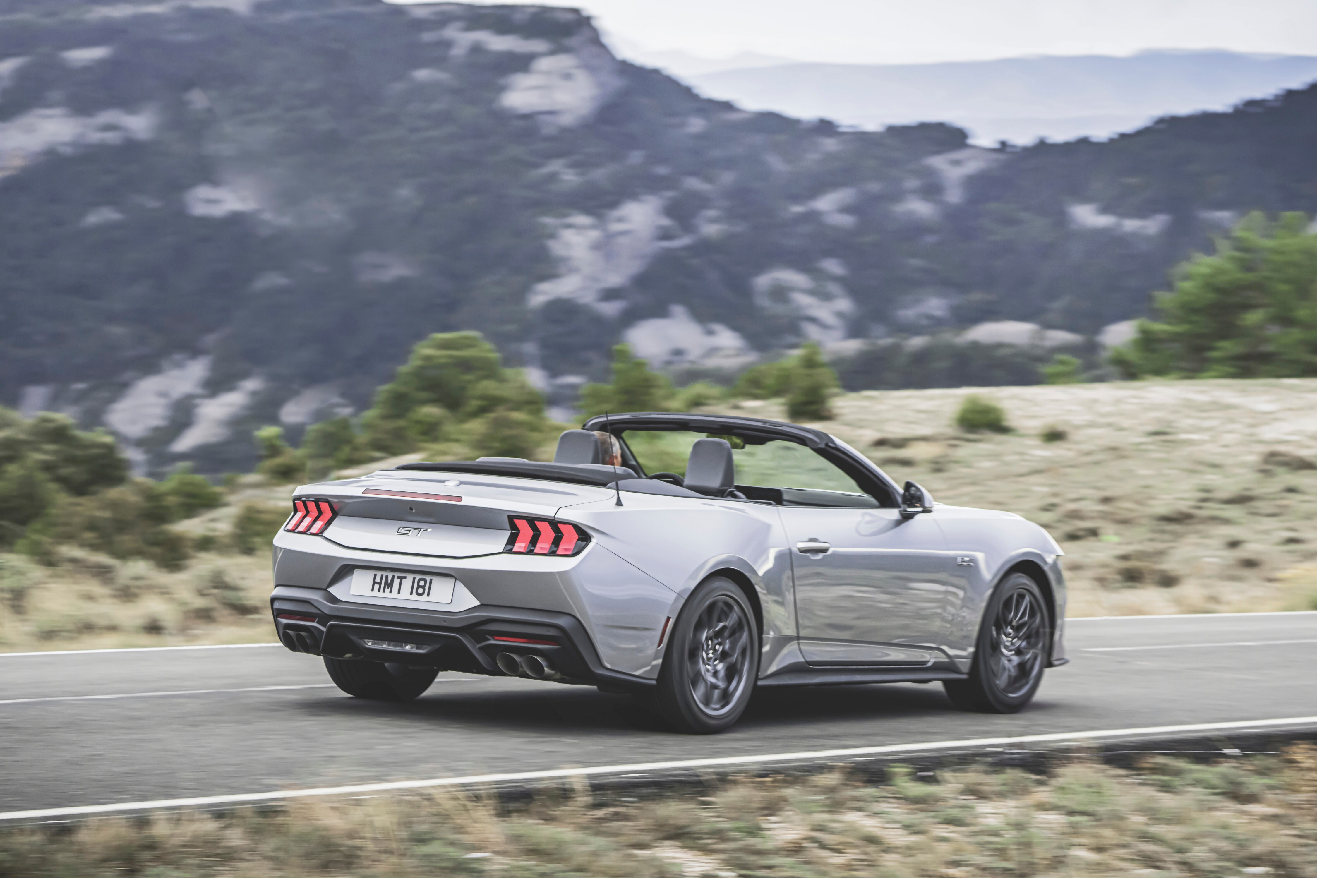 silver mustang driving with top down