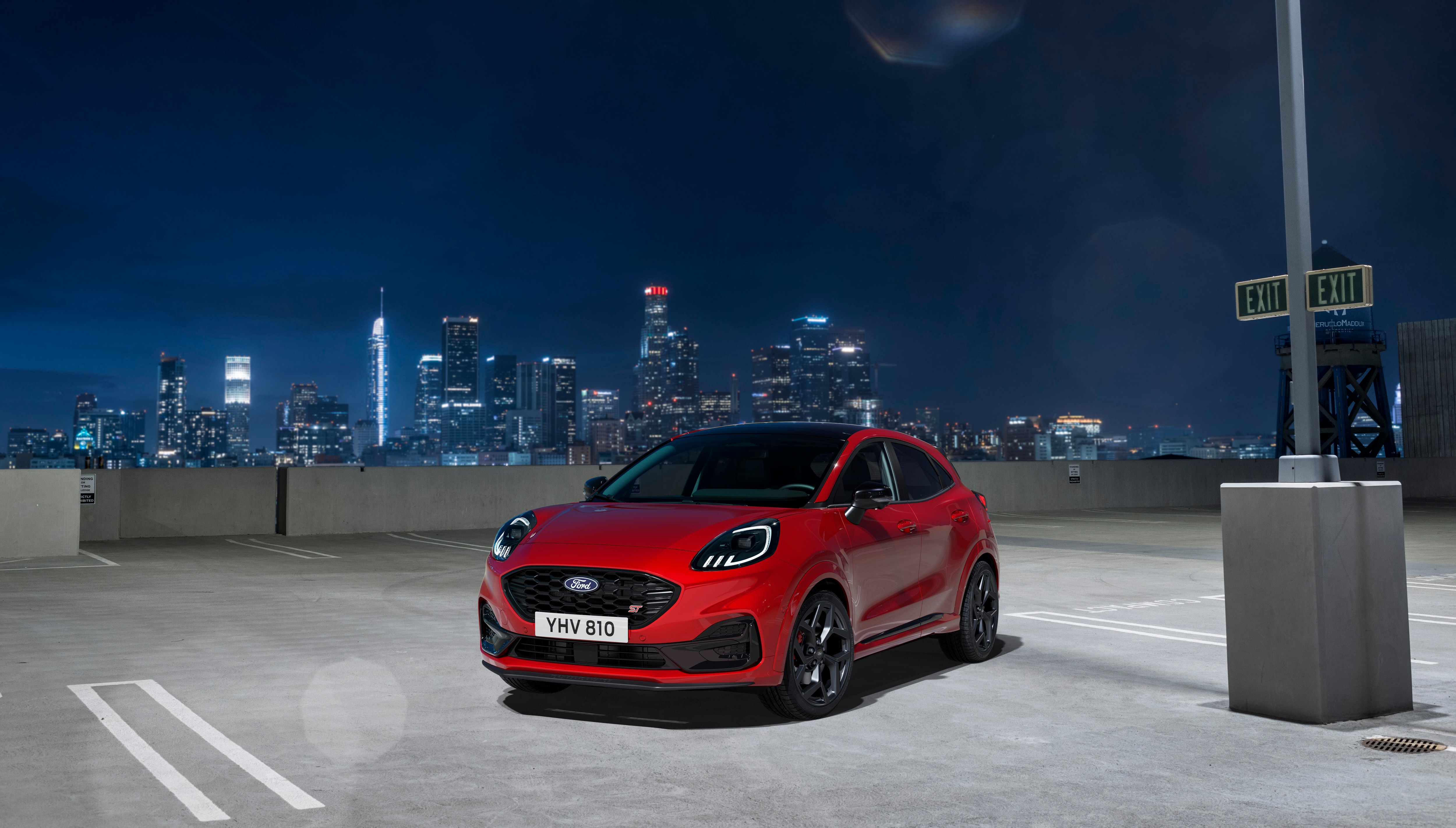 a red car at night in a parking tower