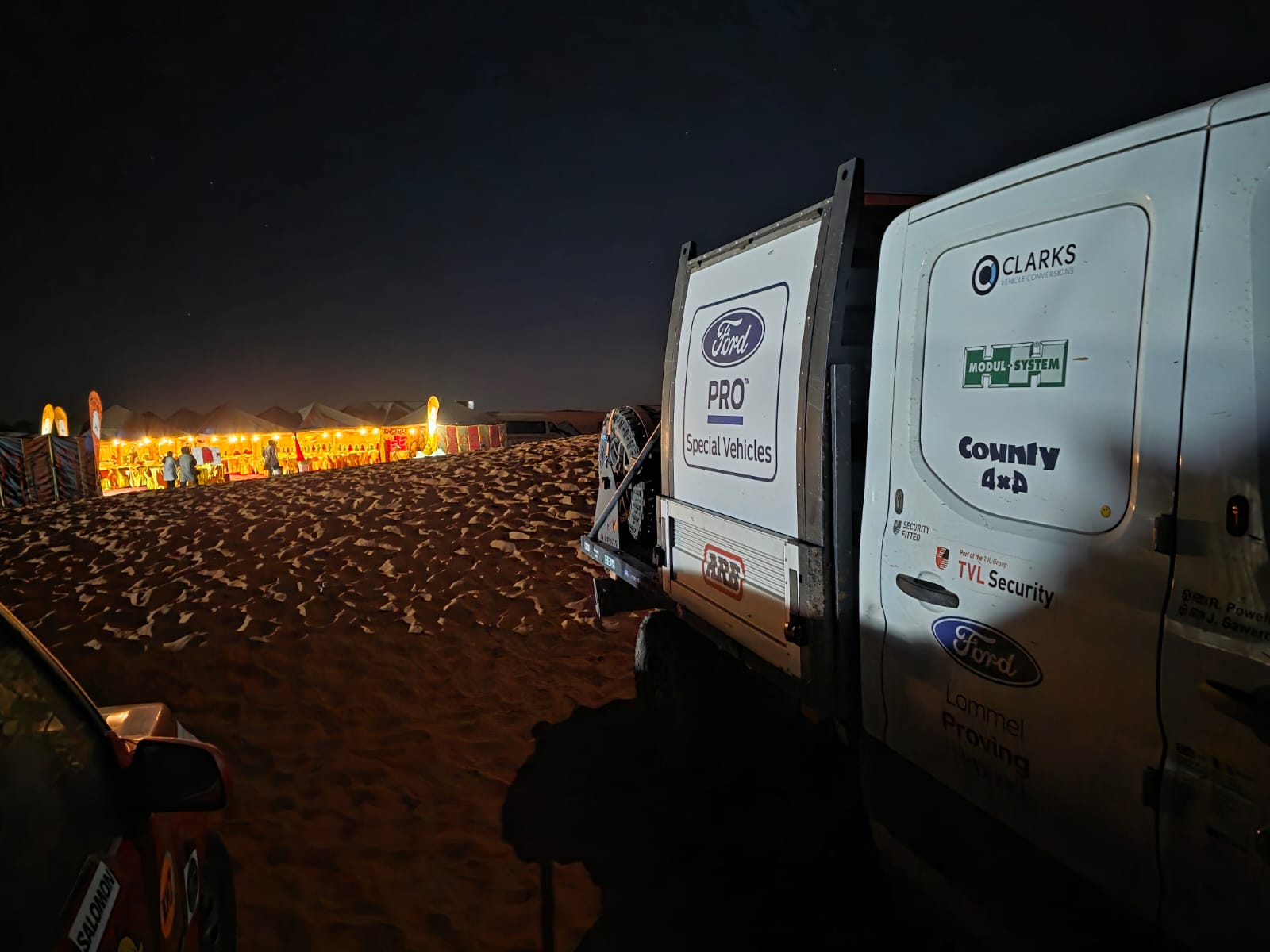 Transit in rally livery parked by camp at night