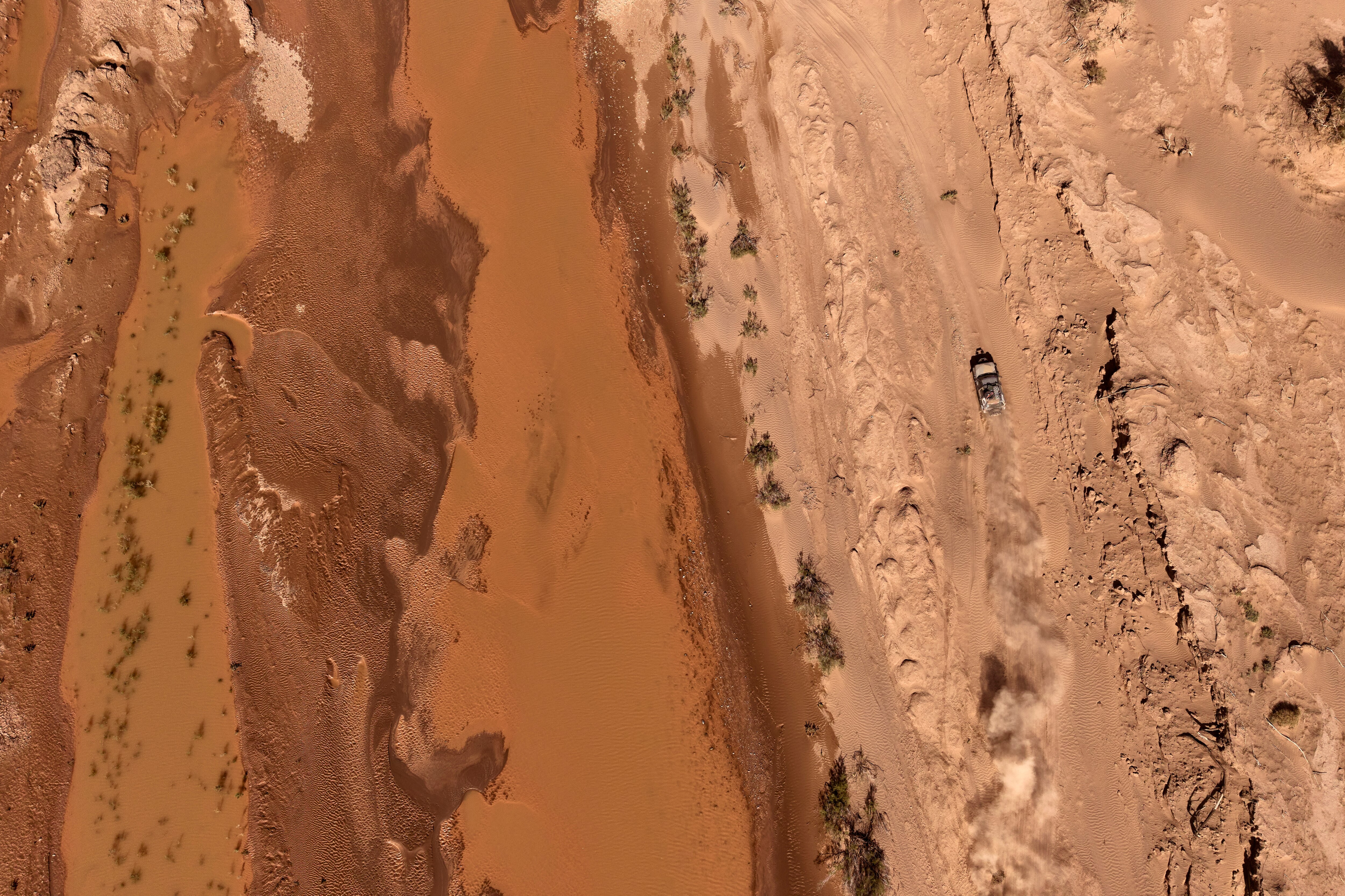 Aerial view of sandscape with one vehicle driving through