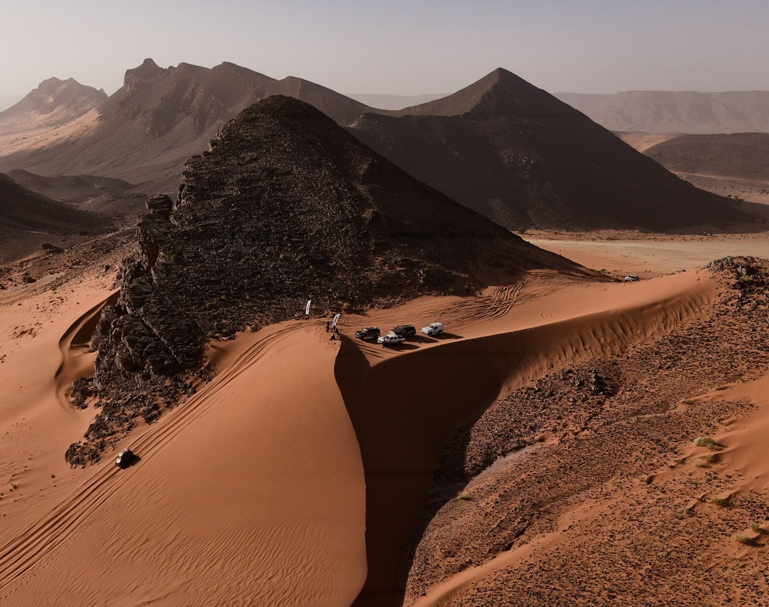Vehicles negotiating very steep downhill sand dune