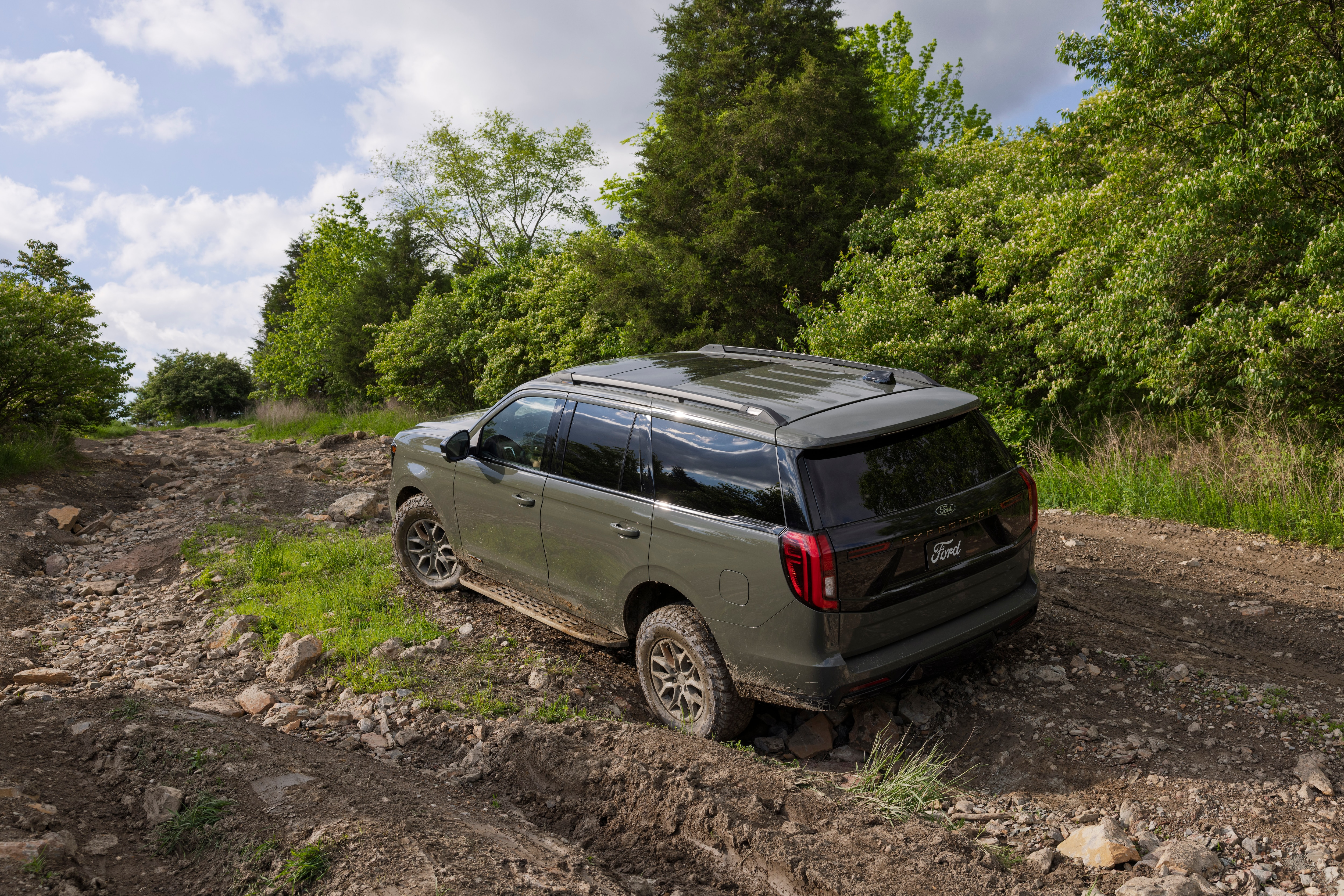 2025 Ford Expedition Tremor driving on rugged terrain in a forested area. 