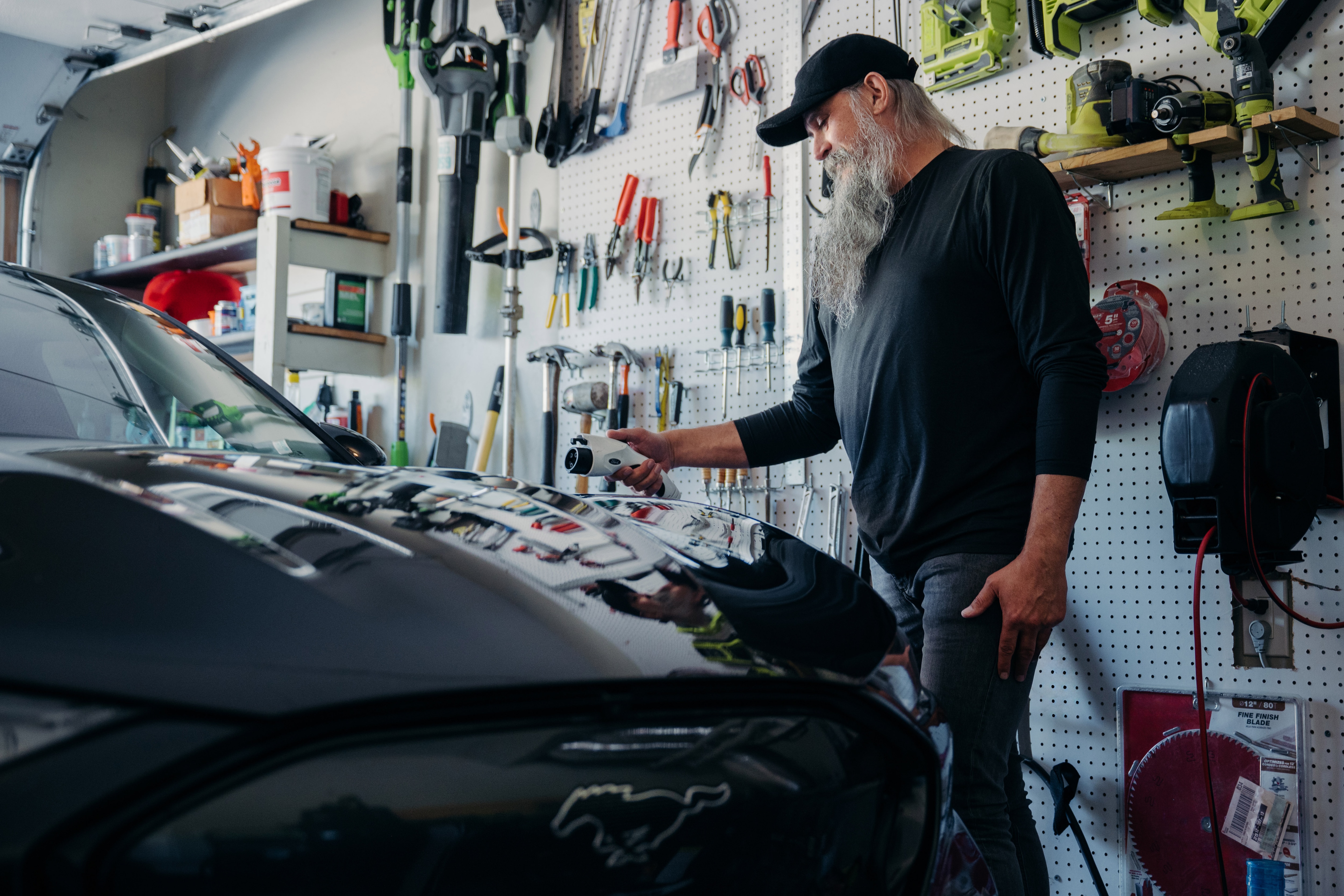 A man charges his 2022 Mustang Mach-E Premium in his garage