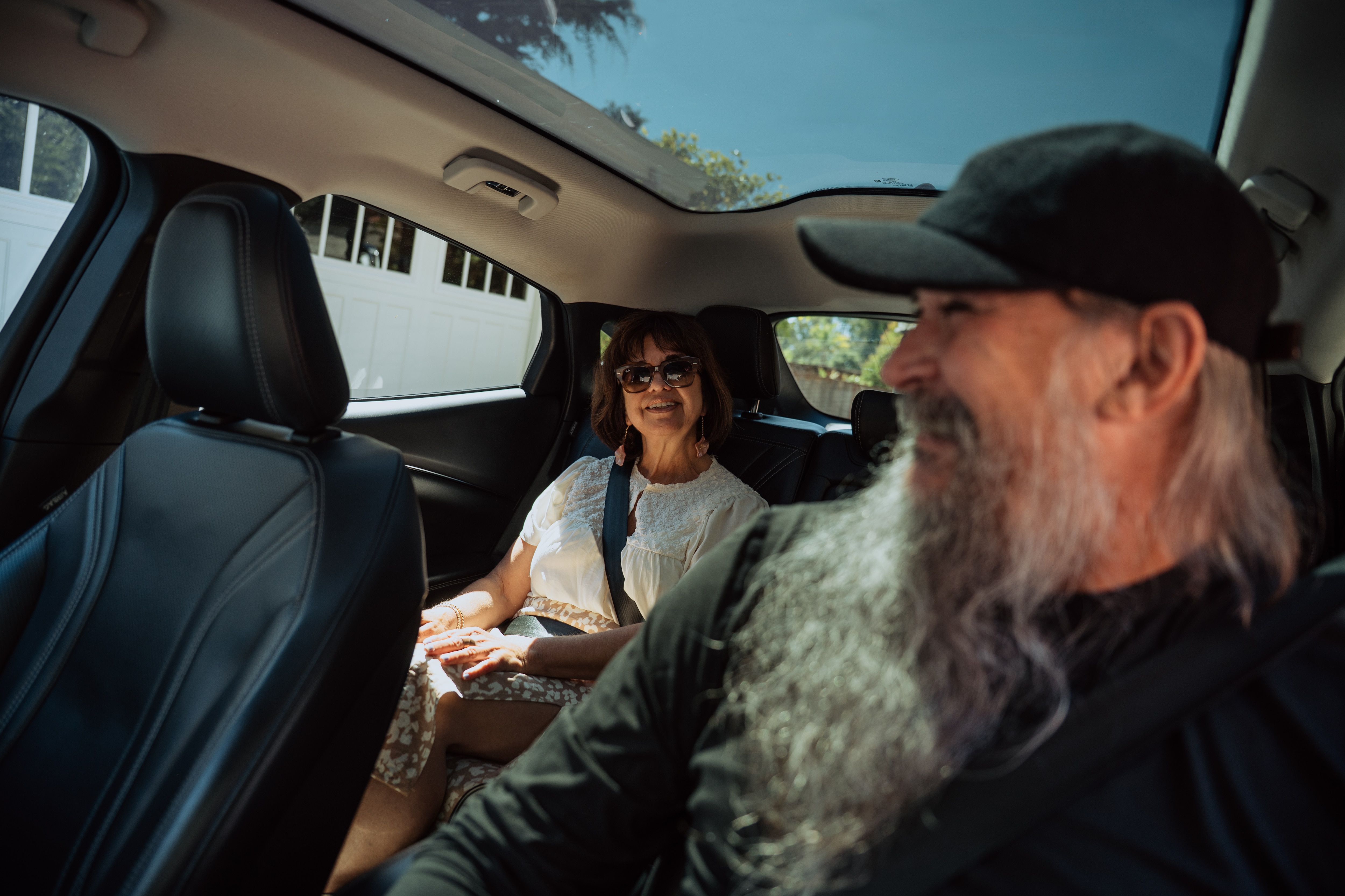 A man chats with his happy passenger in his 2022 Mustang Mach-E Premium
