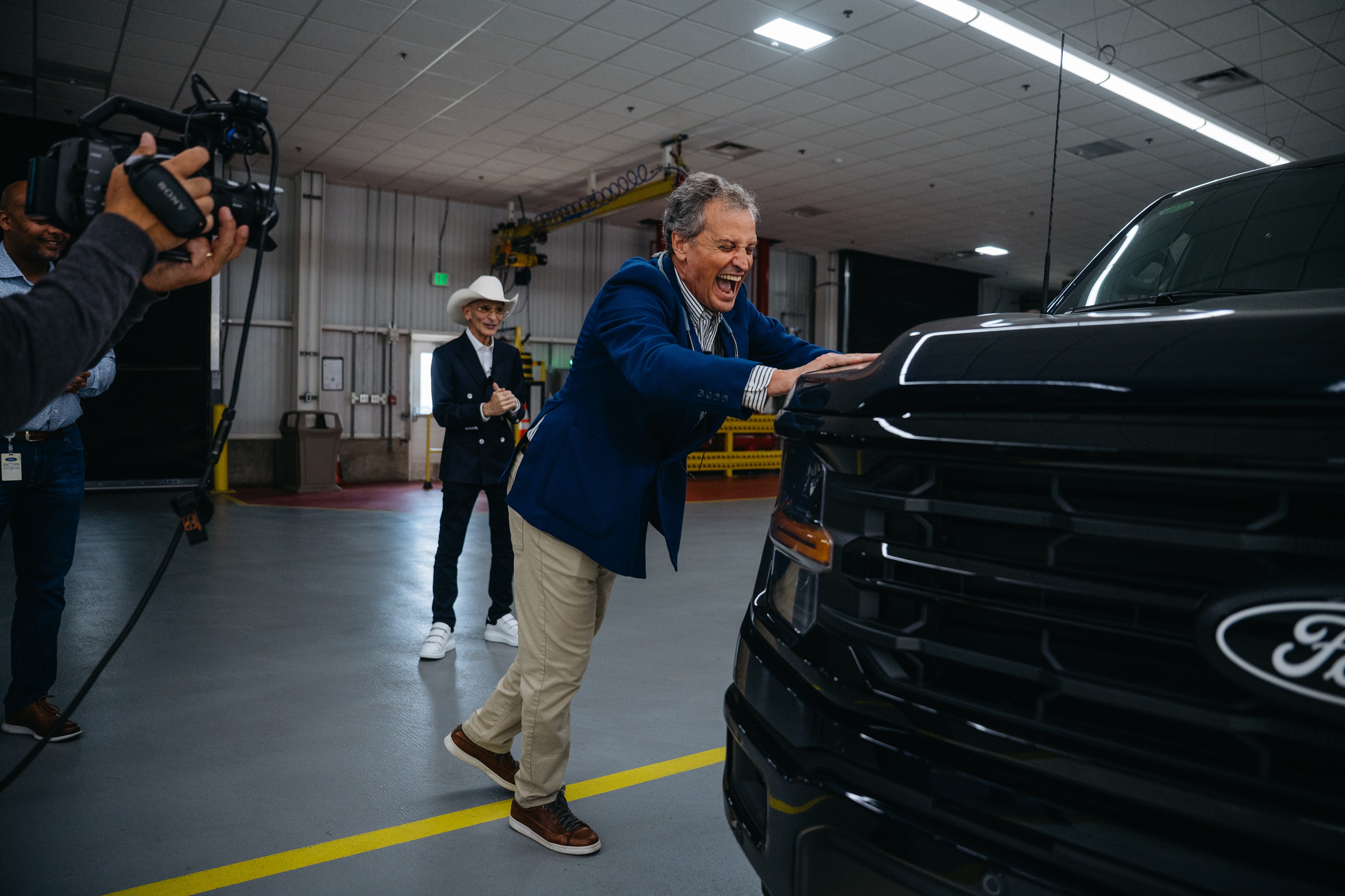 Marc Fogel reacts alongside Richard Bazzy, owner of Shults Ford and Shults Lincoln in Pennsylvania, upon being surprised with a new Ford F-150 truck at Dearborn Truck Plant on Monday, May 5, 2025. (Optional equipment shown.)