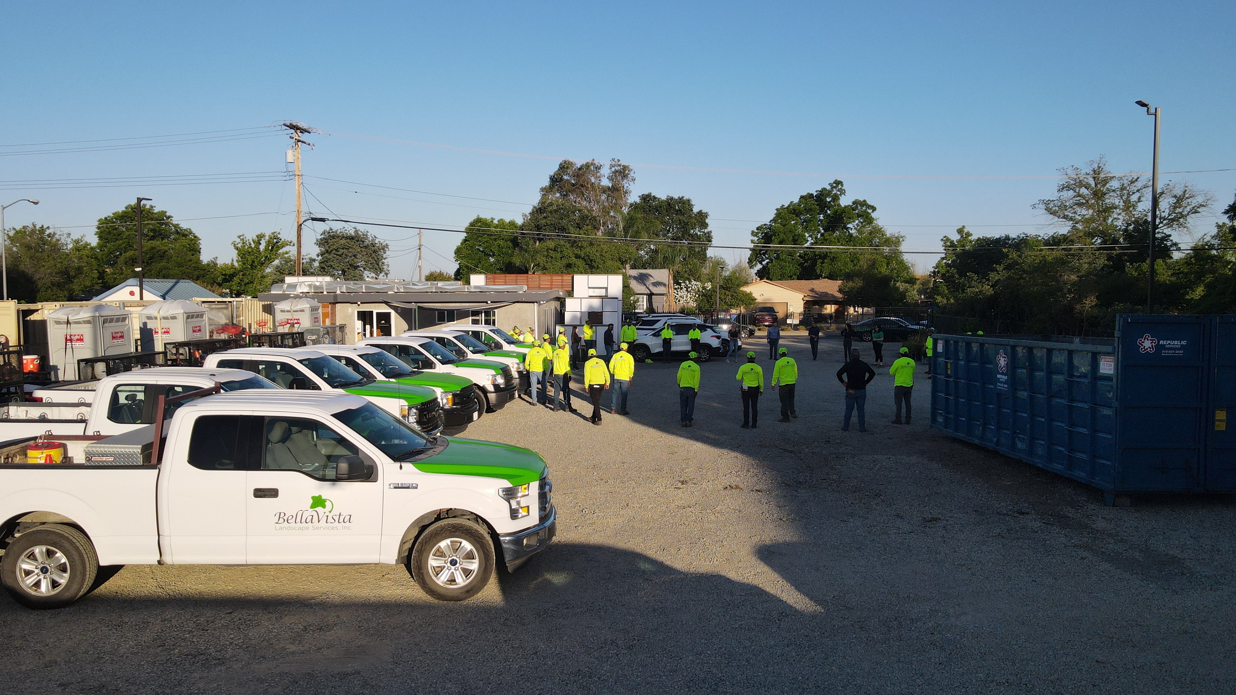 BellaVista employees gather for their morning stretch, surrounded by fleet vehicles. 