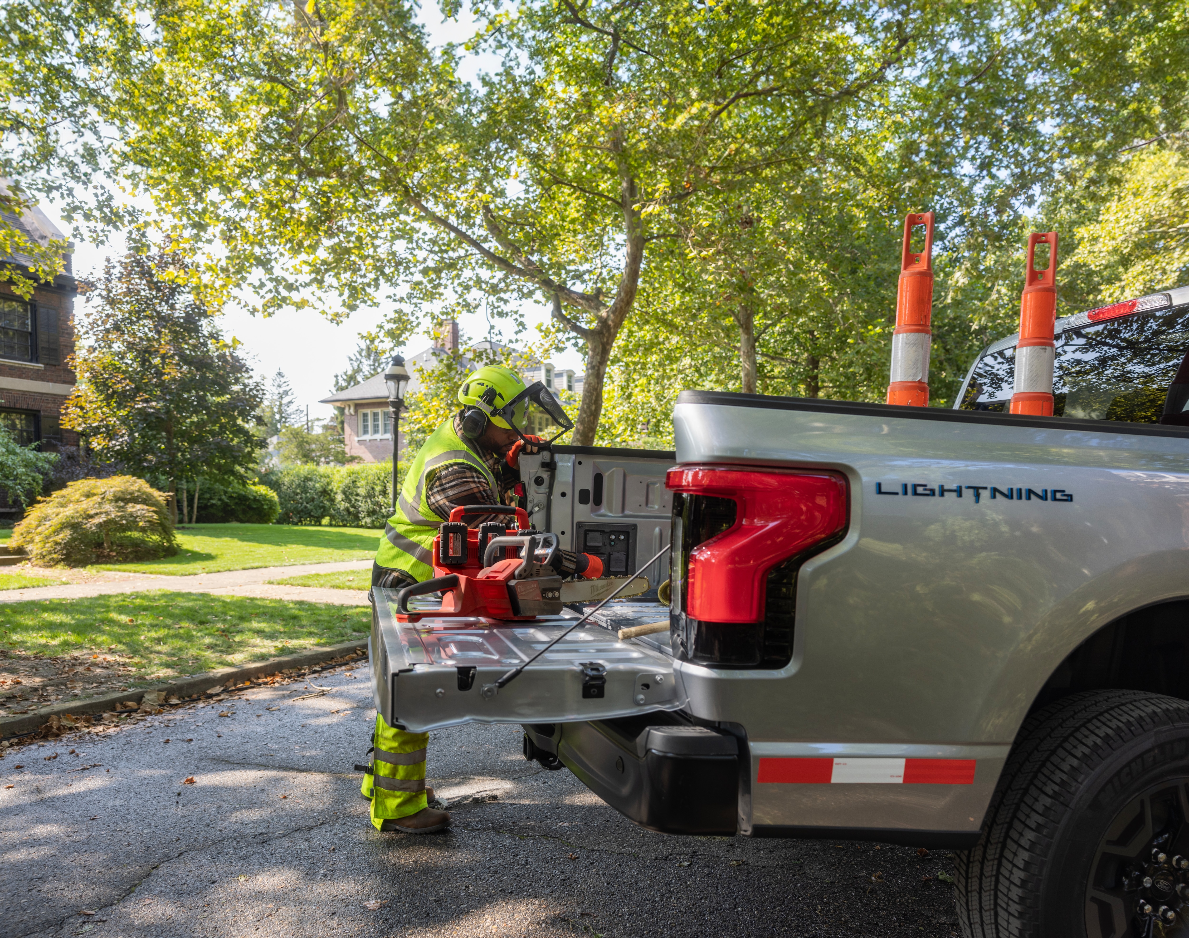 A worker unloads tools from the bed of an F-150 Lightning. 