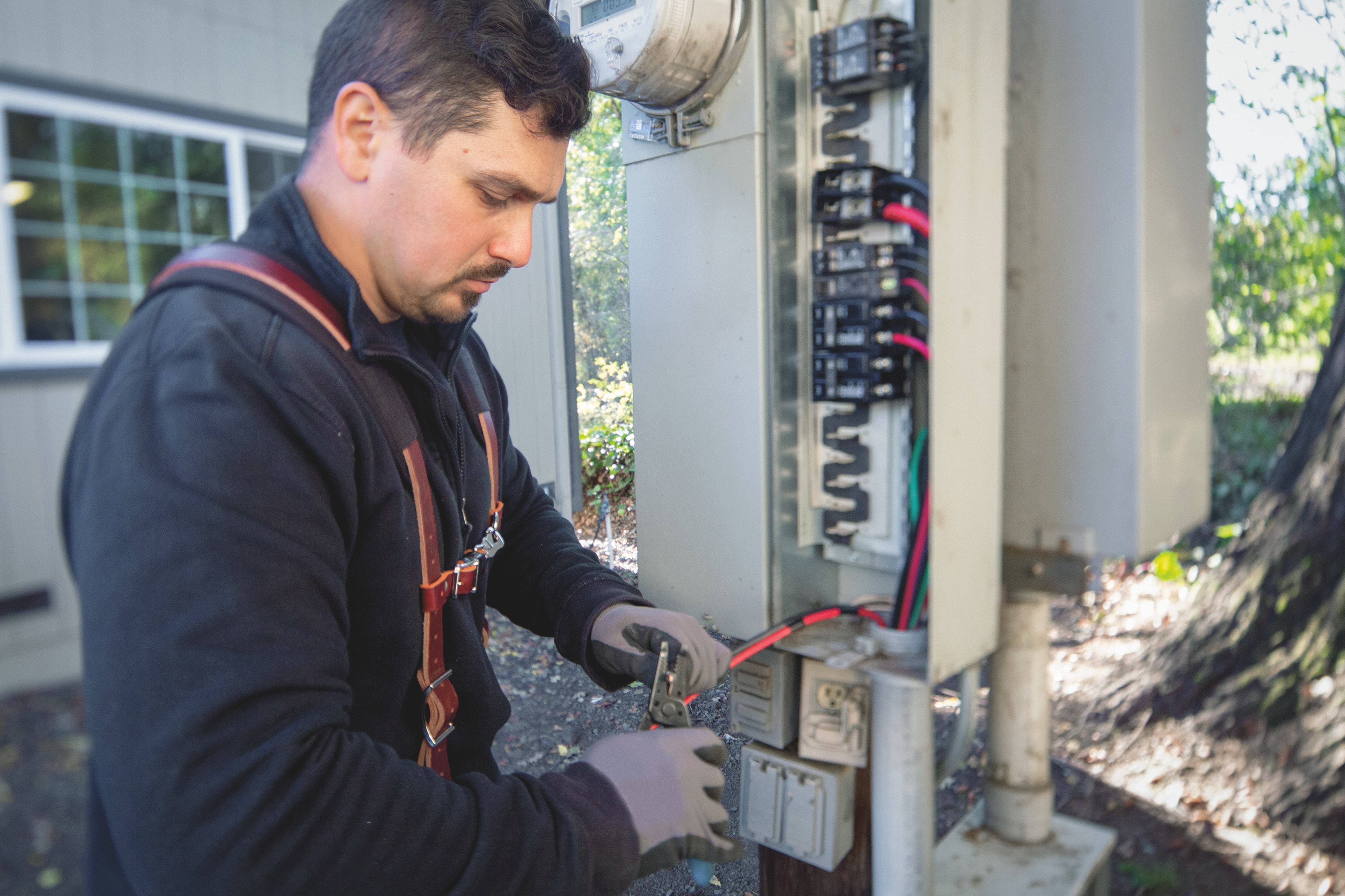 A man works inside of an electrical box.