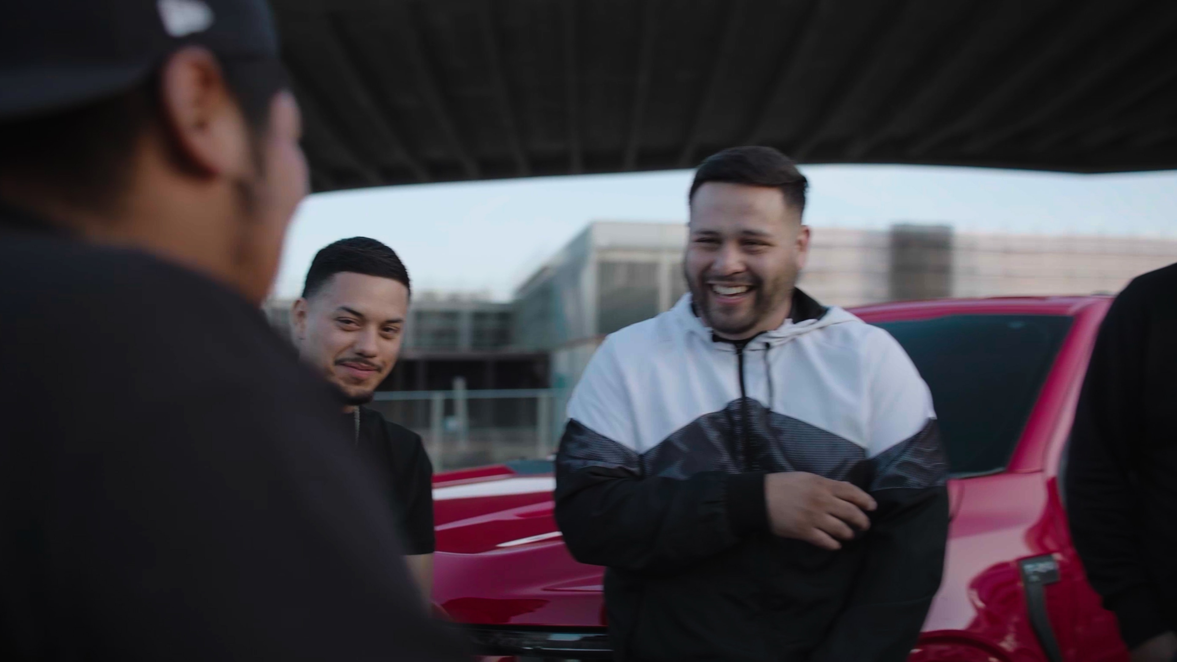 A group of people stand in front of a street truck laughing. 