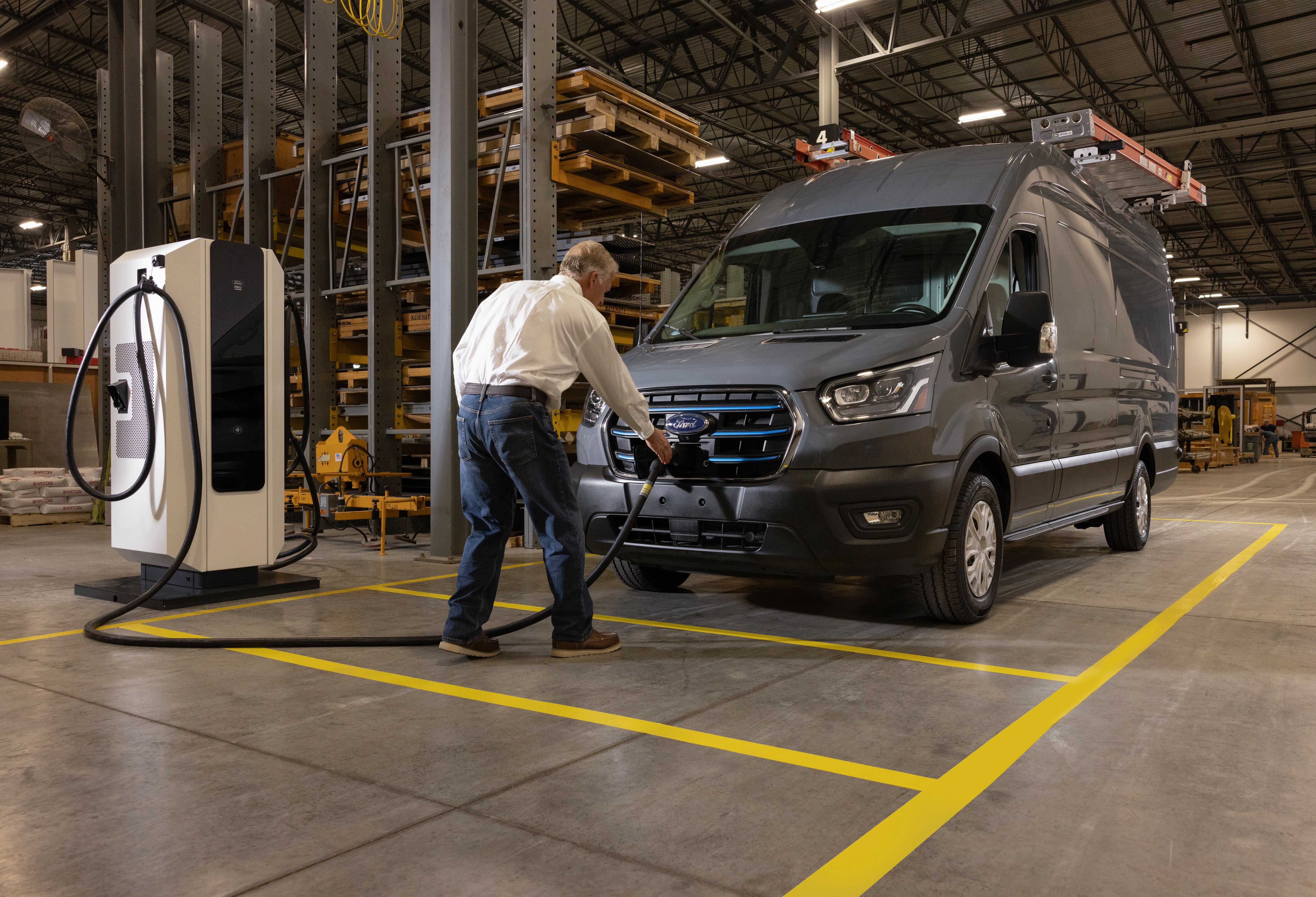 A man hooks an E-Transit van up to a DC Fast Charger.