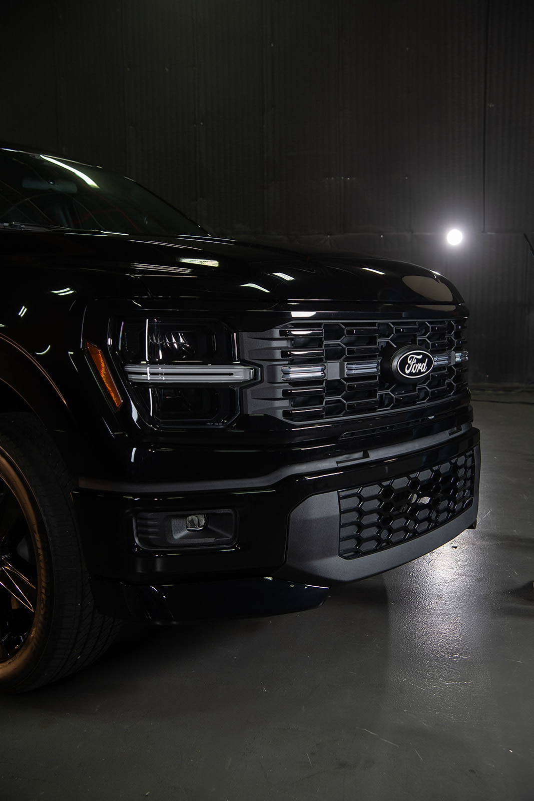 The grille of the new Ford F-150 Lobo shown in a dark room.