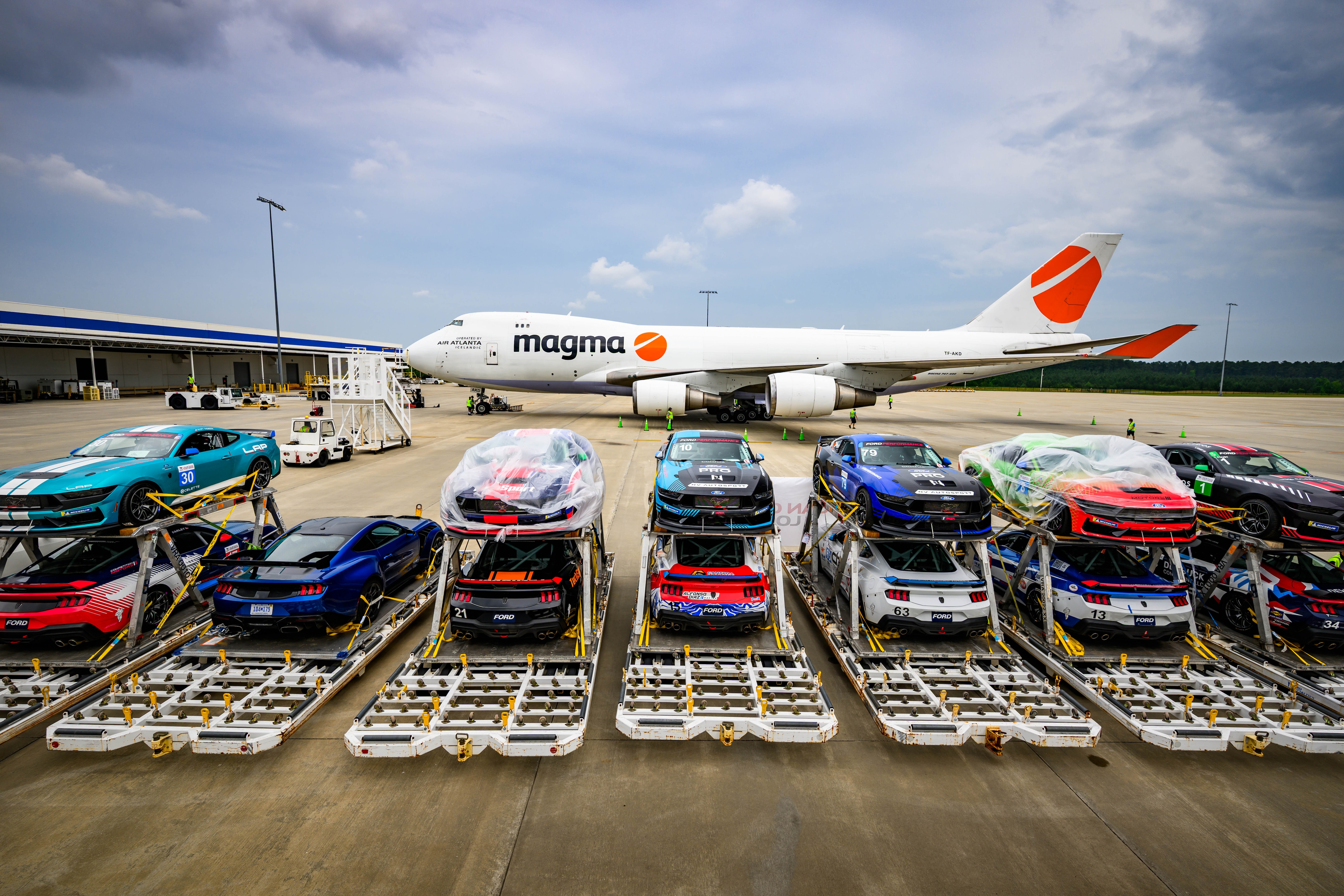 Race cars awaiting loading onto an airplane.