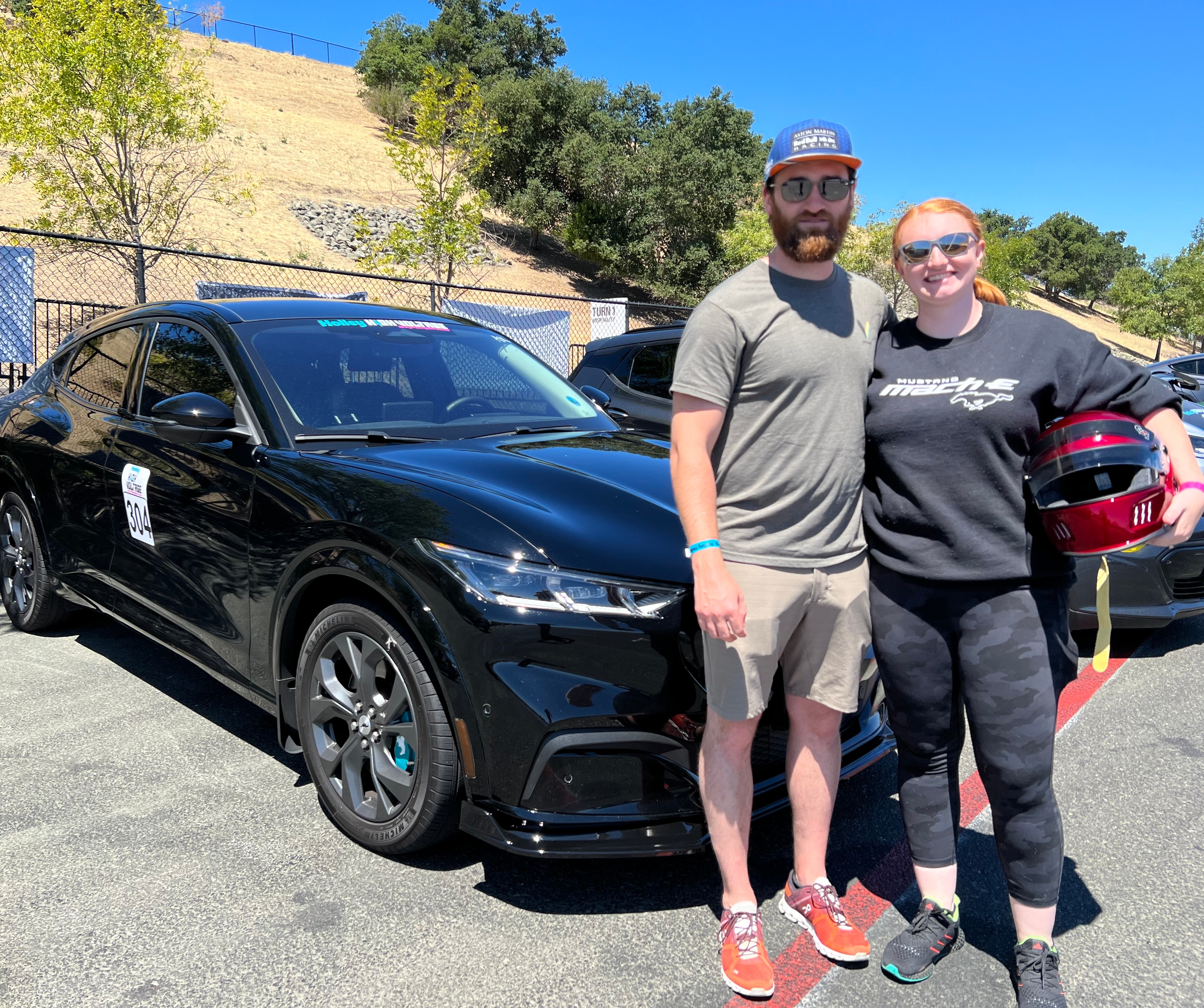 Sophie and her husband, Evan, with their 2021 Mustang Mach-E.