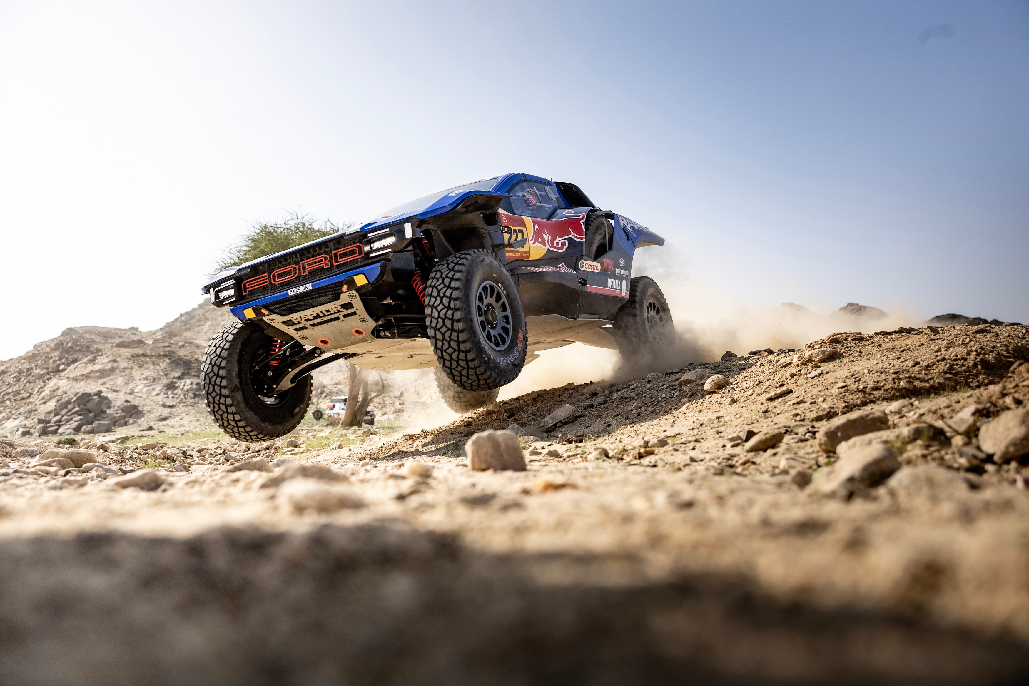 A Ford off-road vehicle jumps over rocks at Dakar.