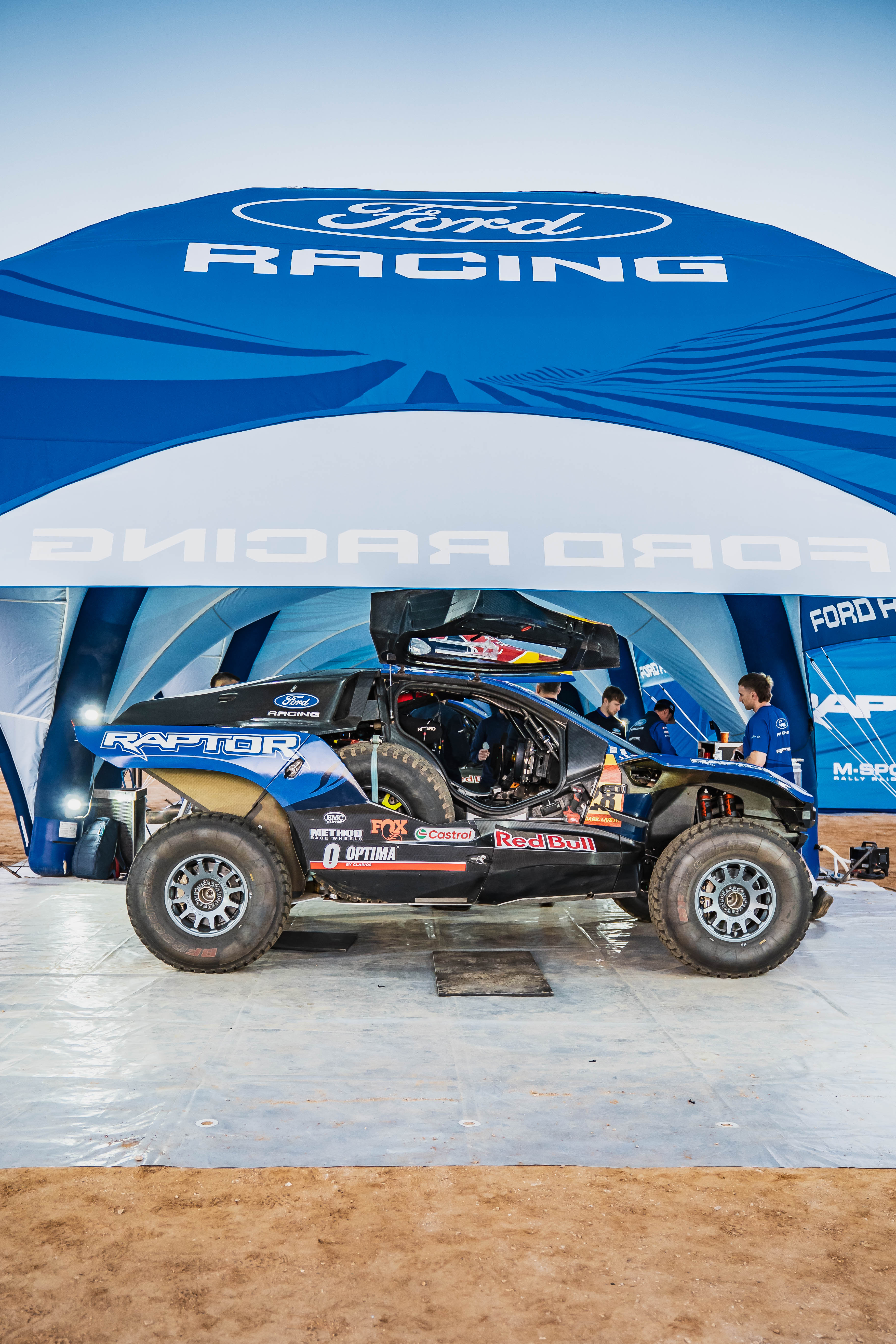 Ford Raptor T1+ shown at Dakar under a Ford Racing tent.